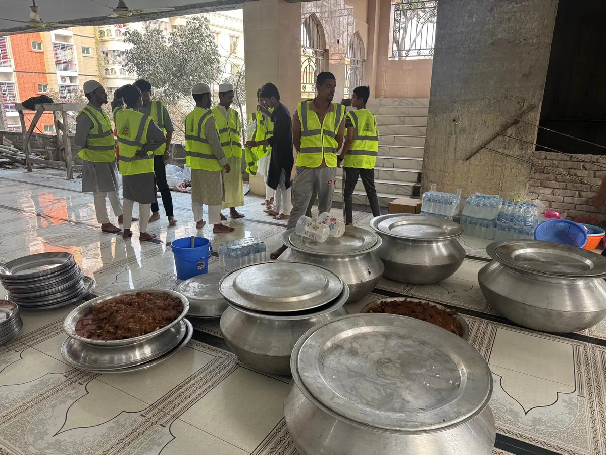 Large cooking pots and food preparation area outside the mosque