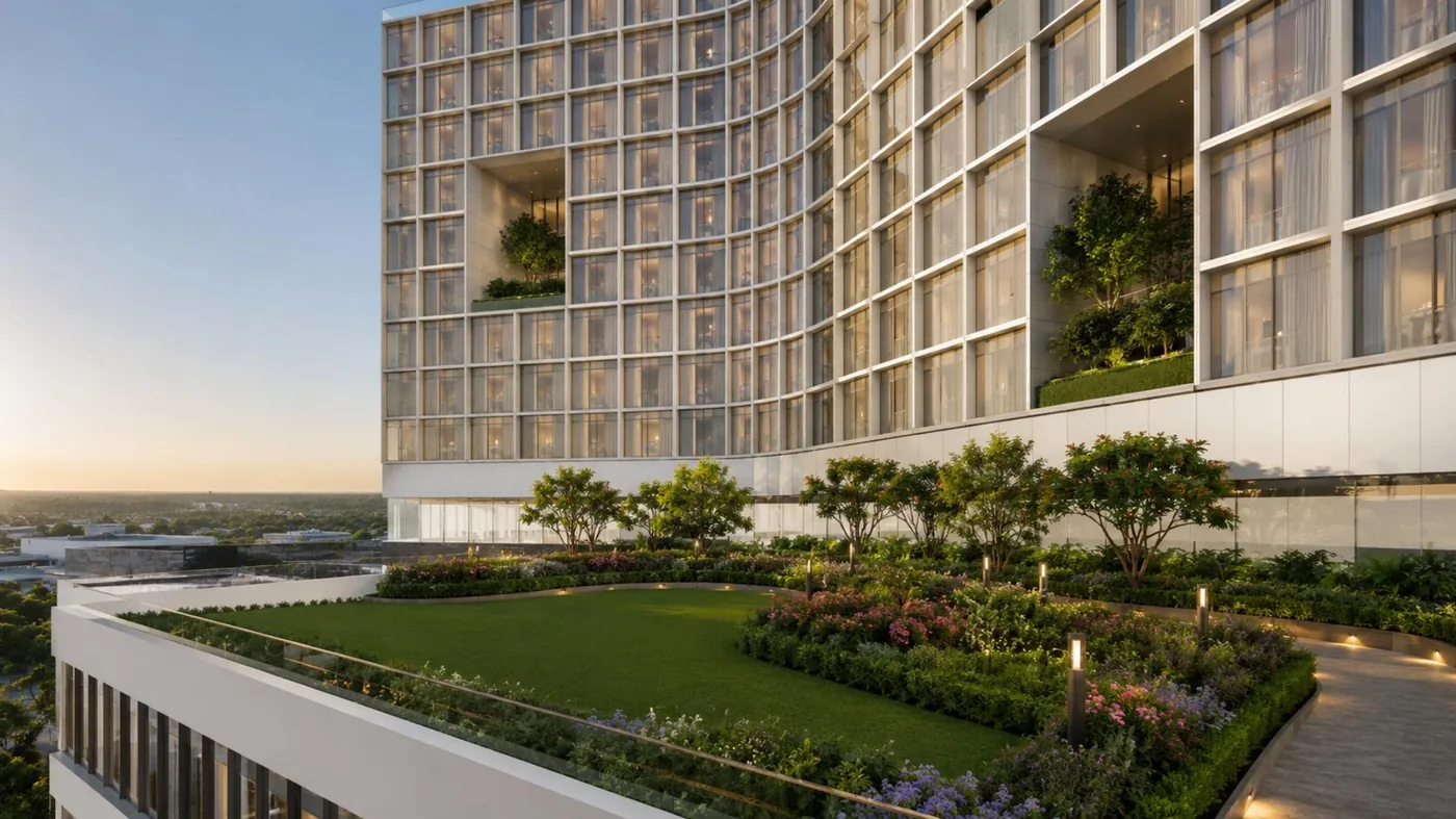 Landscaped podium roof garden at Al-Safa Tower with lawn, flower beds and mature trees, overlooking Uttara at sunset